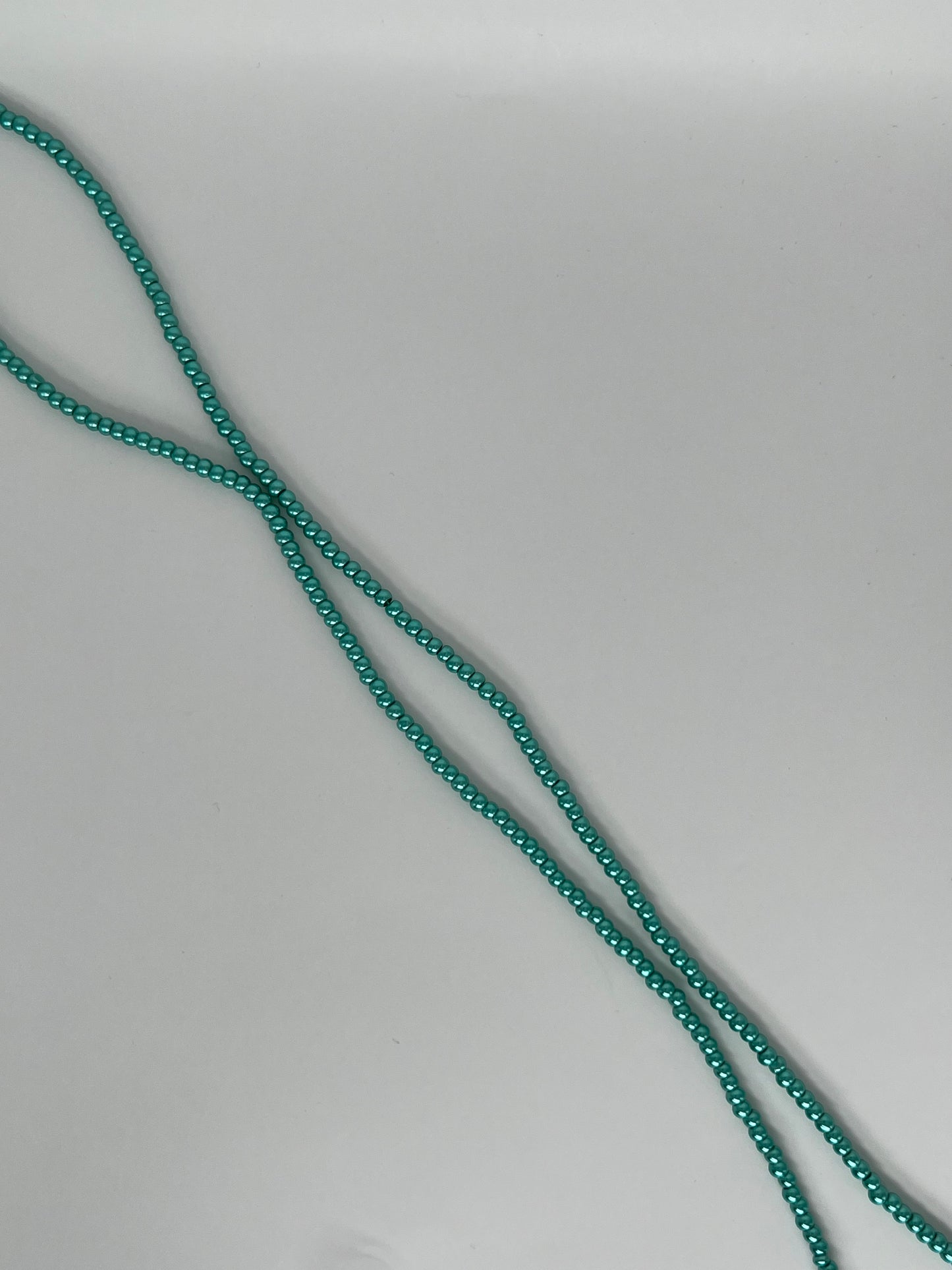 Sträng med vaxade glaspärlor mörkgrön, 3mm
