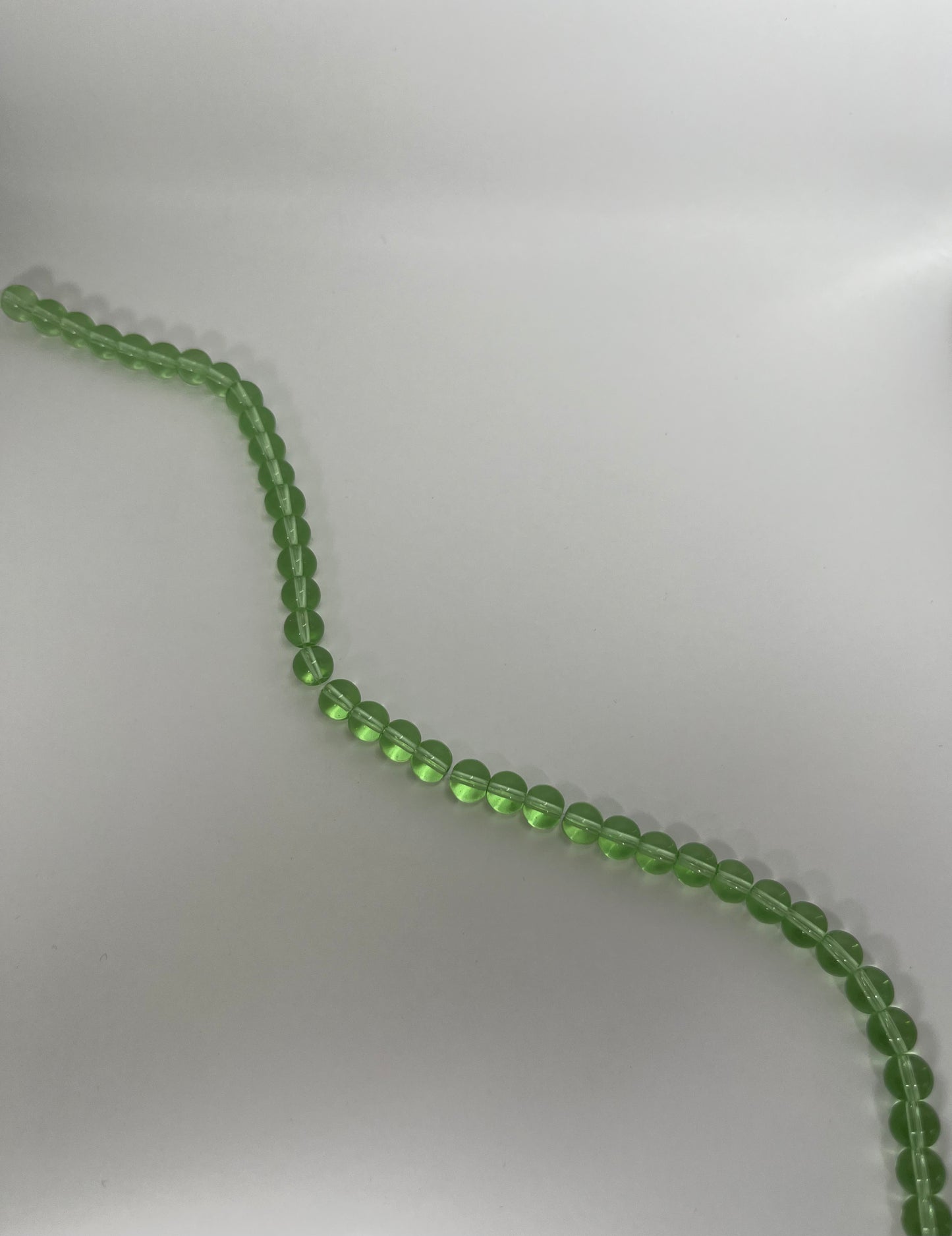 Sträng med runda glaspärlor, klargröna, 8 mm