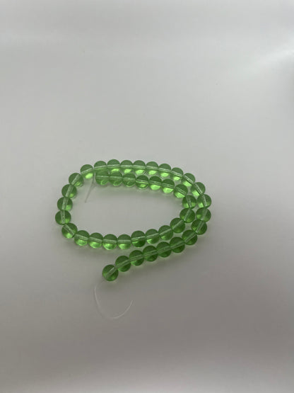Sträng med runda glaspärlor, klargröna, 8 mm