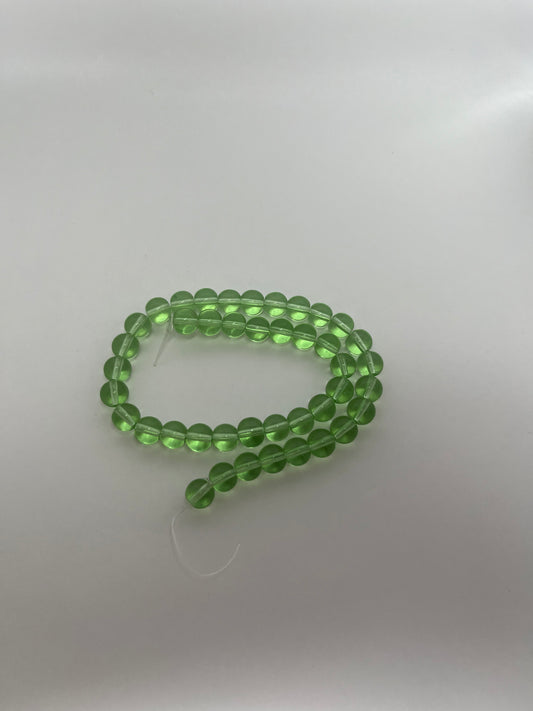 Sträng med runda glaspärlor, klargröna, 8 mm