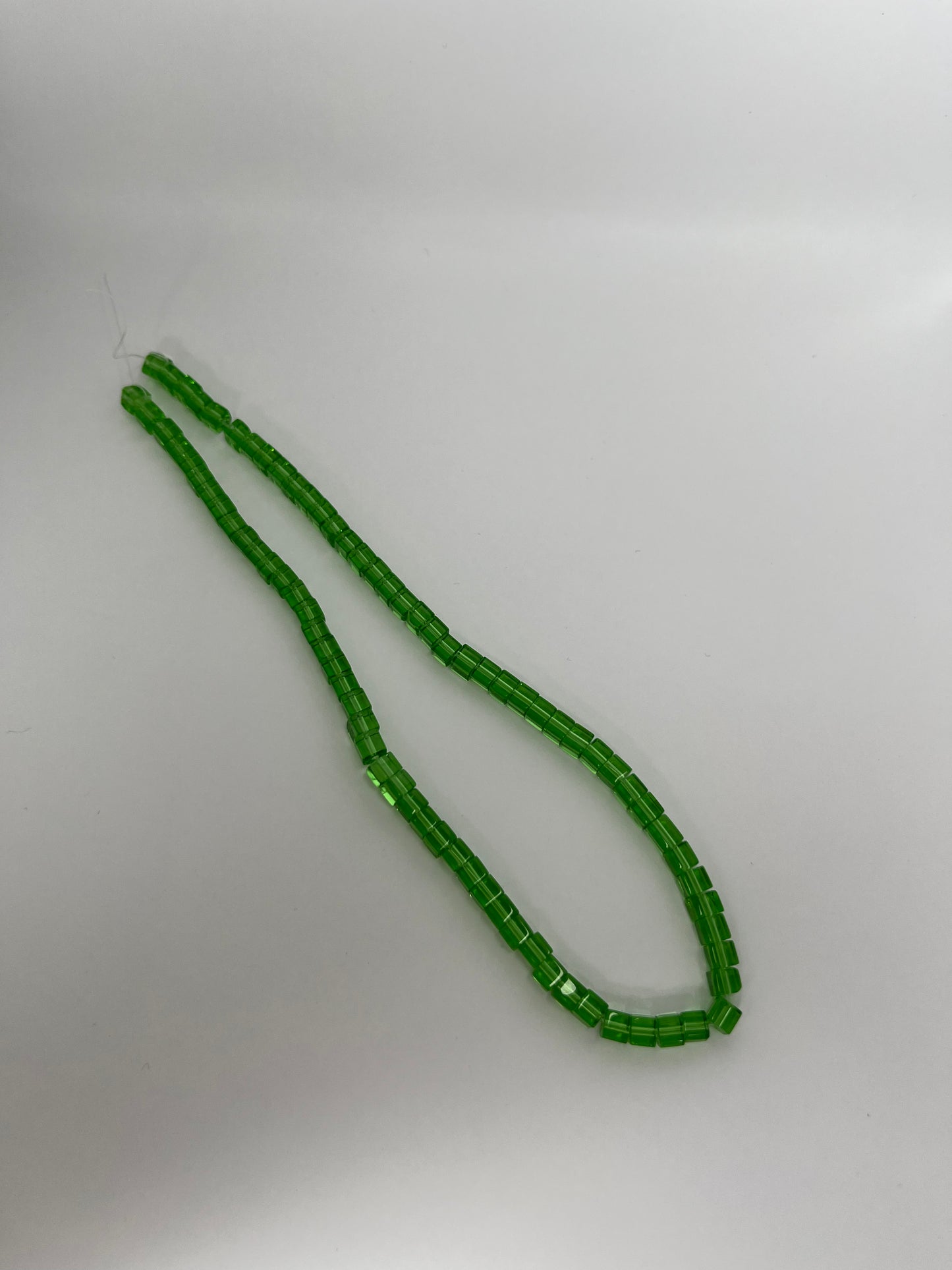 Sträng med kubformade glaspärlor, klar ljusgröna, 4mm
